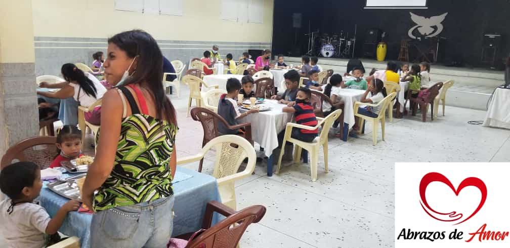 Decenas de niños comparten una comida durante una jornada del comedor comunitario.