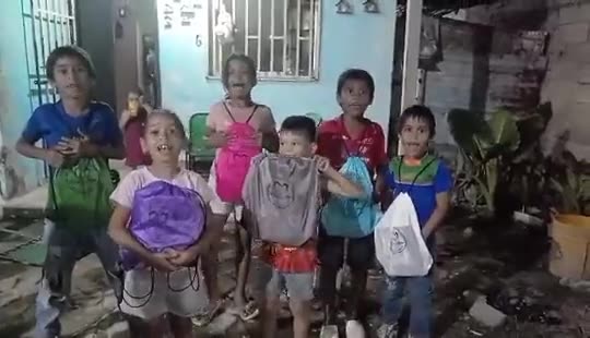 Niños de la comunidad reciben sus kits en una jornada de entrega.