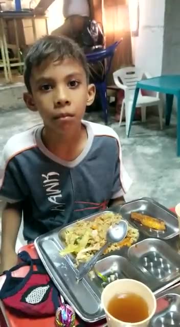 Niño disfruta su almuerzo durante una jornada de alimentación.